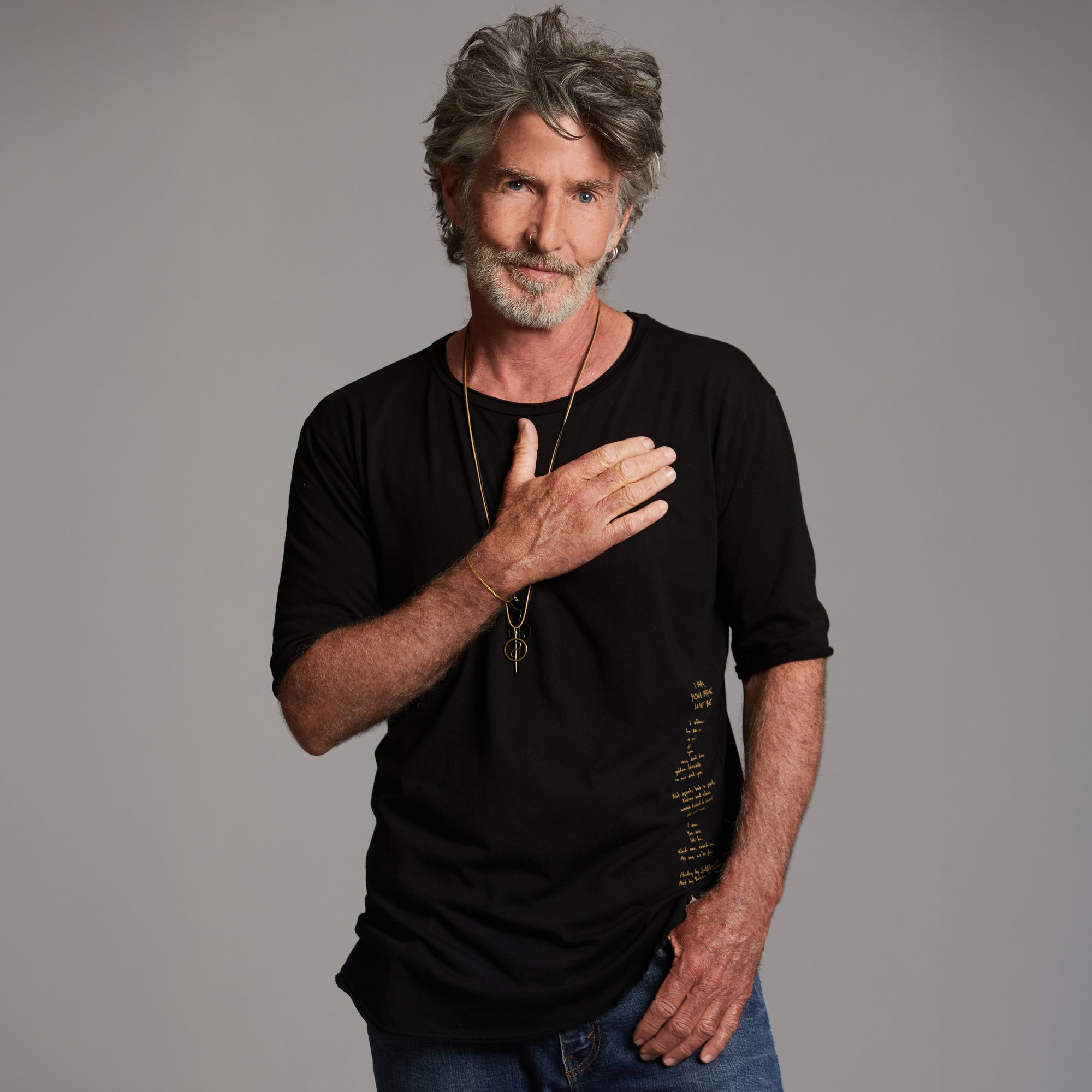 Man modeling a crew neck t shirt with gold graphics